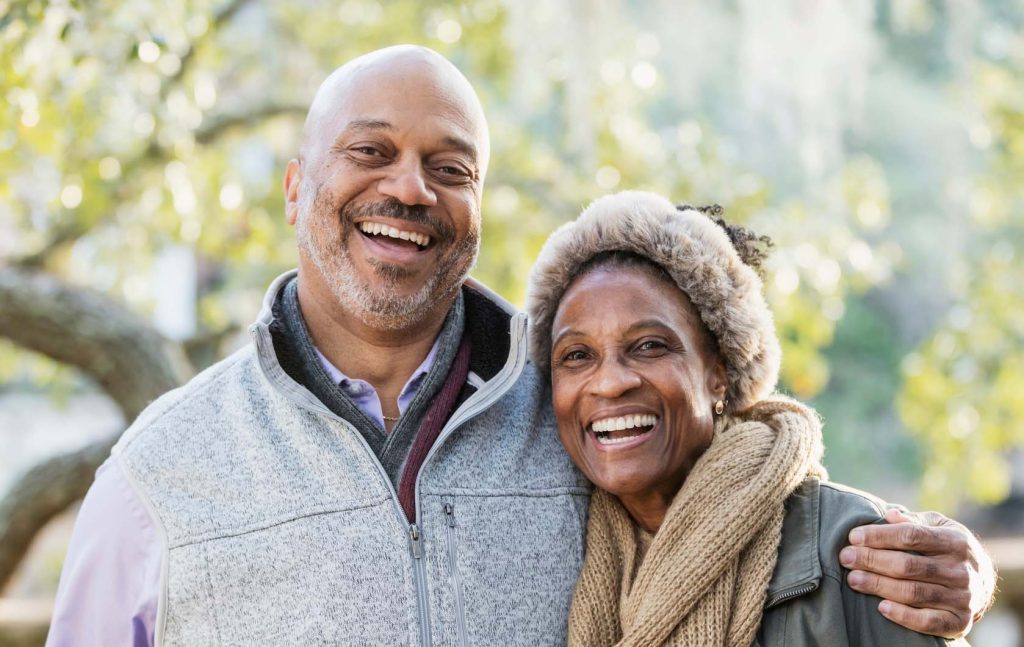 Mature, smiling African-American couple at the park.