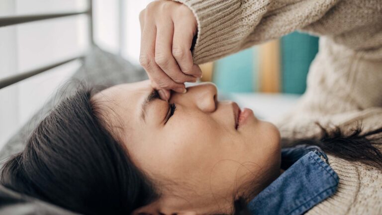 Young woman holding her head in discomfort due to pain.